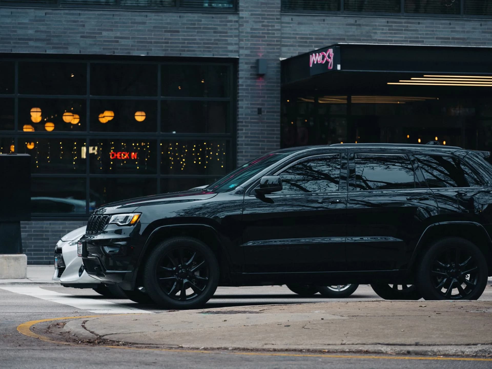 Illustrative dark SUV outside a hotel entrance