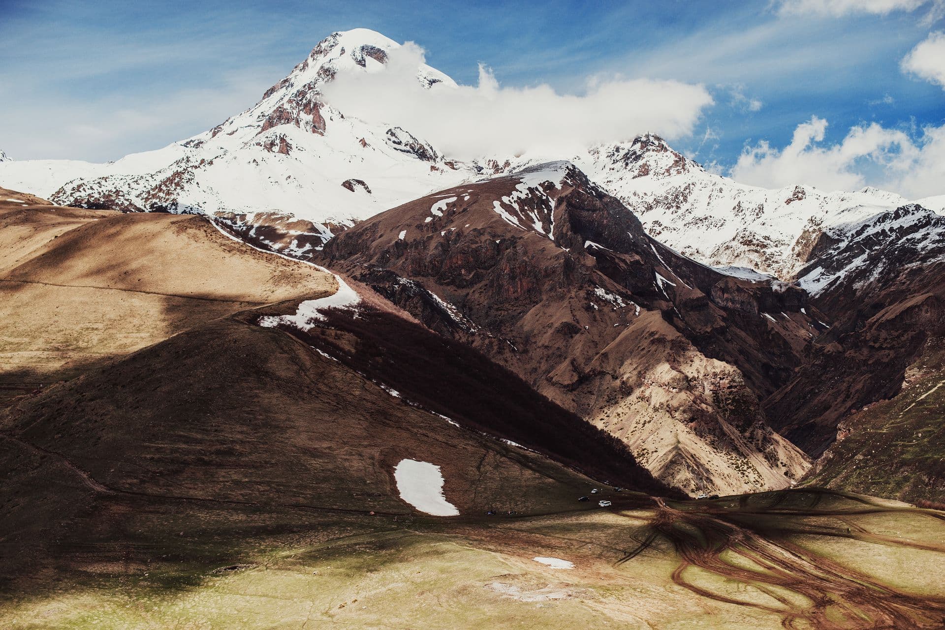 Snow-covered Mount Kazbek above the rugged valleys of Kazbegi